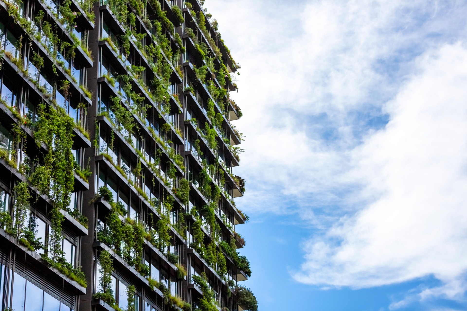 Apartment building with vertical gardens, sky background with copy space